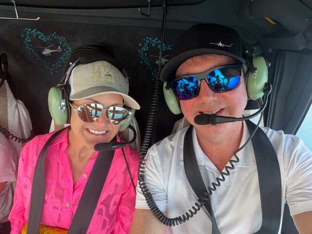 The Willises smiling for a selfie aboard their helicopter in Australia